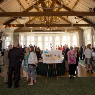 A formal gathering with people socializing in a decorated hall.