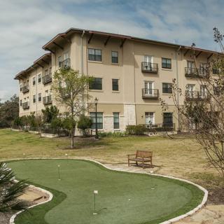A residential building with a well-maintained lawn and greenery.