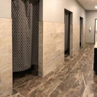 A modern bathroom interior featuring tiled floors and privacy shower curtains.