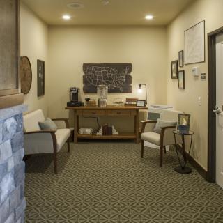A cozy waiting room with seating and a coffee station.