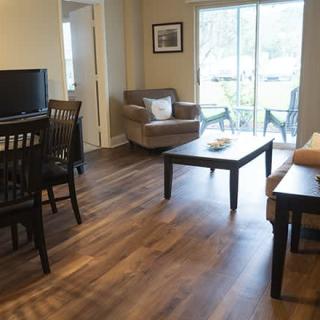 A cozy living room and dining area with modern furniture and wooden flooring.