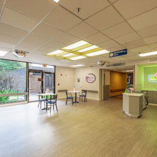 A spacious and modern waiting area in a healthcare facility, featuring bright lighting and comfortable seating.