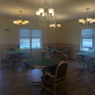A well-lit dining room with several tables and chairs arranged neatly.