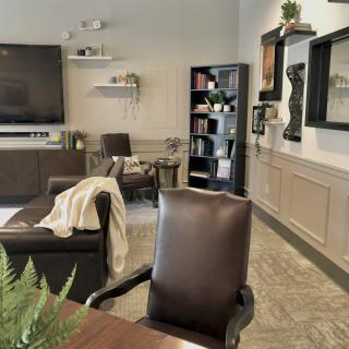 A modern office space with comfortable seating, a large TV, and stylish decor.