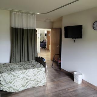 A cozy room featuring a bed, curtains, and a television.