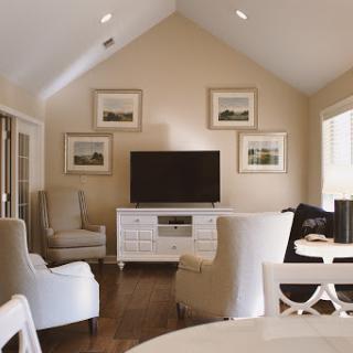 A stylish and comfortable living room featuring a modern television setup and elegant seating arrangements.