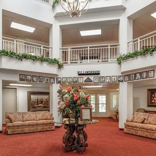 A spacious lobby with elegant decor, featuring comfortable seating and decorative plants.