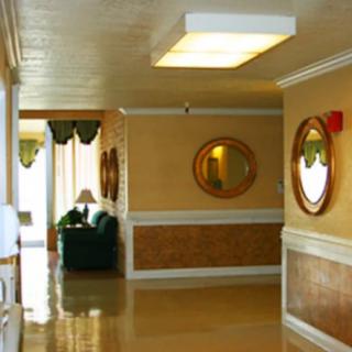 A well-lit hallway interior with mirrors and comfortable seating.