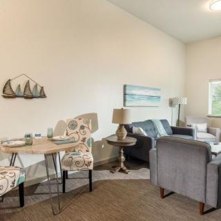 A cozy living and dining area featuring modern furniture, decorative wall art, and a warm carpet.