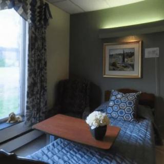 A cozy room with a window, decorated with a chair, table, and flowers.