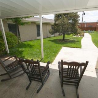 A peaceful patio with rocking chairs overlooking a garden walkway.