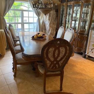 A cozy dining room featuring a wooden table set with chairs and a decorative china cabinet.