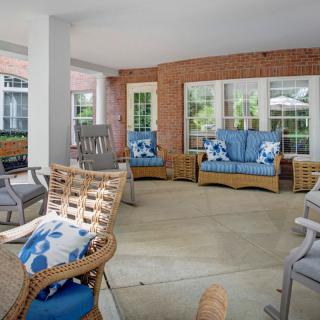 A cozy outdoor patio area with wicker furniture and blue cushions.