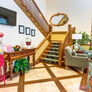 A cozy living area featuring a wooden staircase, comfortable seating, and decorative elements.