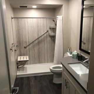 A modern and clean bathroom with a shower area, toilet, and sink.