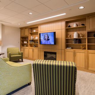 A cozy living room with comfortable seating, a television, and built-in bookshelves surrounding a fireplace.