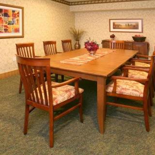 A cozy dining room with a large wooden table surrounded by matching chairs.