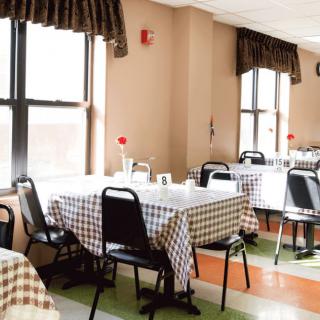 A well-lit dining area with tables covered in checkered tablecloths.