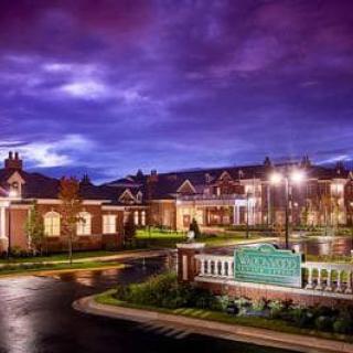 A well-lit building under a cloudy night sky.