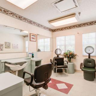 A bright and spacious salon interior with hair dryer chairs and mirrors.