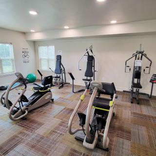 A well-equipped gym room featuring various exercise machines and equipment.