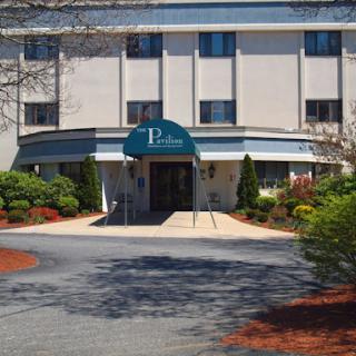 A well-maintained hotel entrance surrounded by lush landscaping.