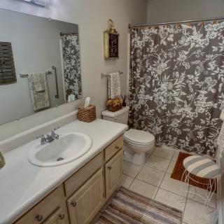 A well-organized bathroom with a floral shower curtain and neatly arranged decor.