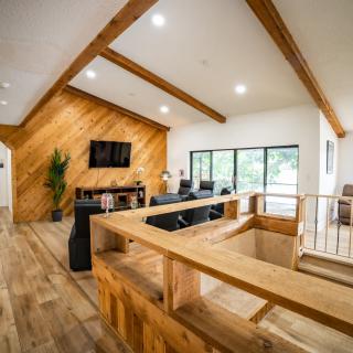 A modern living room featuring wood paneling, a vaulted ceiling, and large windows creating an inviting open space.