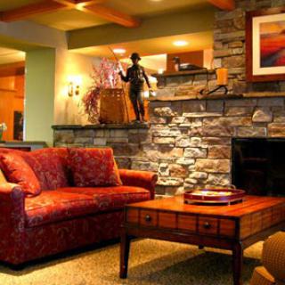 A cozy living room featuring a comfortable sofa, a rustic stone wall, and warm lighting.