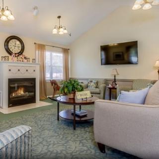 A cozy living room featuring a fireplace, sofa, and television.