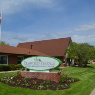 A well-maintained building with a sign and landscaped grounds on a sunny day.