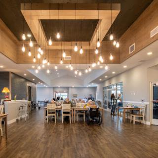 A beautifully designed modern dining area featuring wooden accents and stylish lighting.