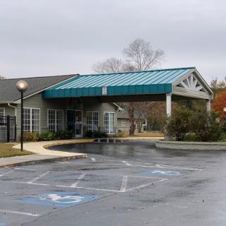 A view of a building entrance under a cloudy, rainy sky.