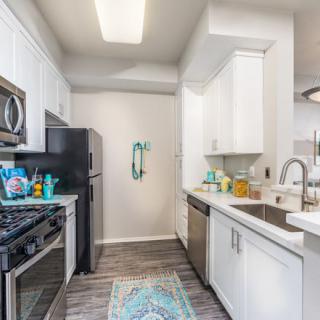 A modern kitchen with white cabinets and stainless steel appliances.
