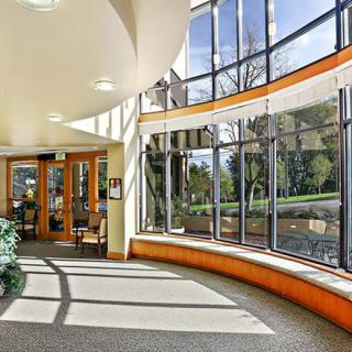 A well-lit modern interior space with large curved windows and a spacious lobby area.