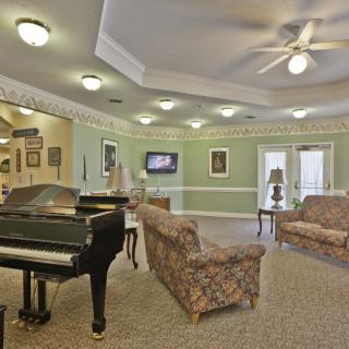 Spacious living room with a grand piano and elegant seating area.