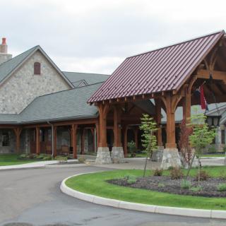 A picturesque building with a wooden entrance and landscaped surroundings.