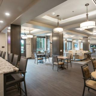 A modern dining area featuring ample seating and stylish lighting.