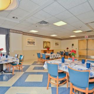 A spacious dining area with neatly arranged tables and chairs, featuring vibrant decor and ample lighting.
