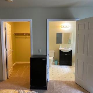 A cozy bedroom featuring a closet and an adjoining bathroom.