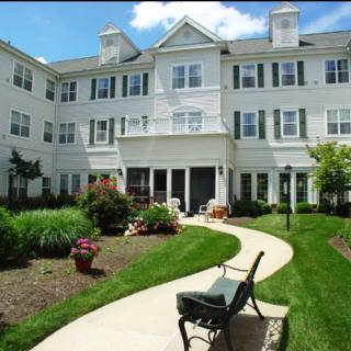 A view of a residential building with a well-maintained garden and pathway.