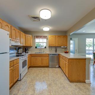A spacious and bright kitchen with wooden cabinets and modern appliances.