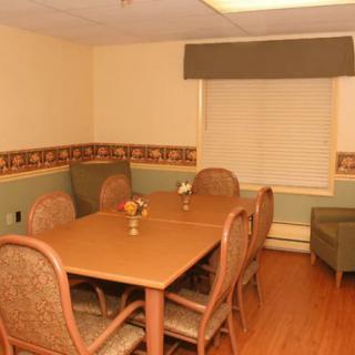 A small conference room with tables and chairs, featuring neutral colors and simple decor.