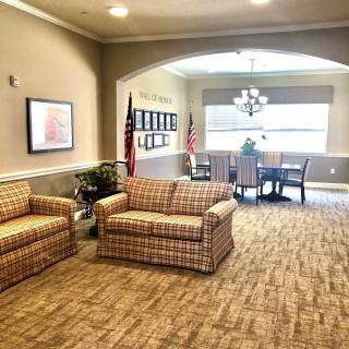 A cozy lobby area with sofas and a table, adorned with flags and soft lighting.