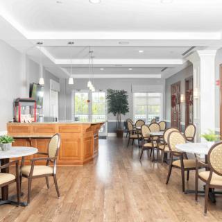 A modern restaurant interior with a bar and neatly arranged tables and chairs.