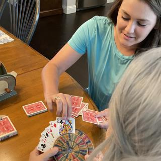Two people playing a card game at a table.