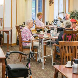 A group of elderly people dining together in a senior living community.