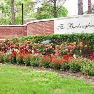 A beautifully landscaped garden with a brick wall and sign reading 'The Buckingham'.