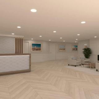 A modern lobby with minimalist design, featuring a reception desk and artwork on the walls.