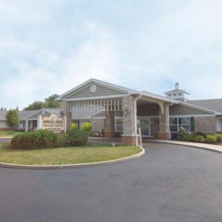 A building with a covered entrance and surrounding landscaped area.